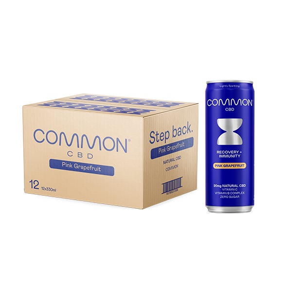 Box of Common CBD Pink Grapefruit drinks alongside a single sleek blue can, featuring 20mg natural CBD, vitamin B complex, and zero sugar, designed for recovery and immunity support.